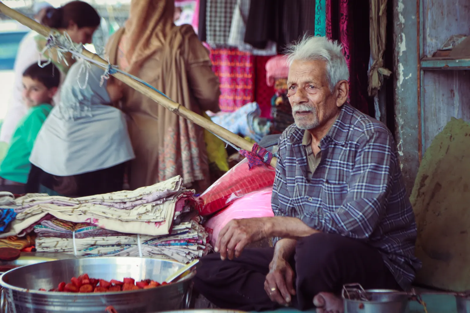 An elderly shopkeeper at his market stall