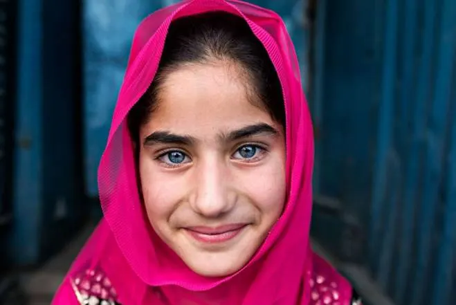 A smiling girl in a bright pink headscarf